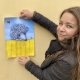 Tania Goryushina håller upp affisch på omslagsbilden till Varför ingen klappar igelkotten.